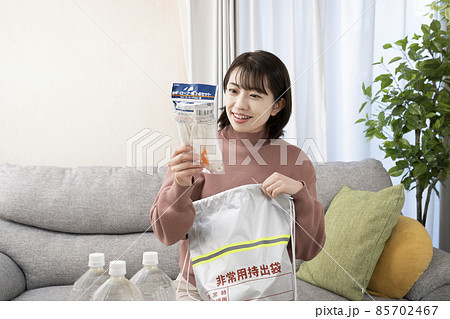 笑顔で非常用持出袋の中身を確認する女性 笑顔で非常用持出袋の中身を確認する女性 85702467