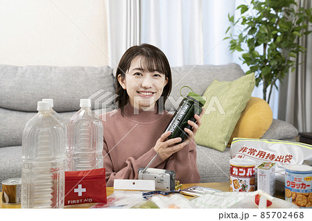 笑顔で非常用持出袋の中身を確認する女性 笑顔で非常用持出袋の中身を確認する女性 85702468
