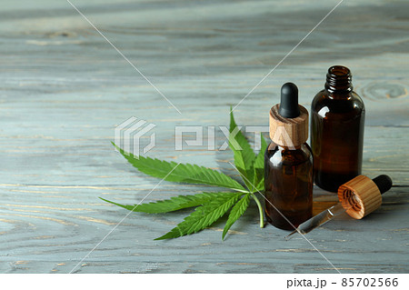 Cannabis leaf and oil on gray wooden background Cannabis leaf and oil on gray wooden background 85702566