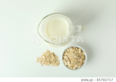 Pitcher of milk and cereals on white background 85702717