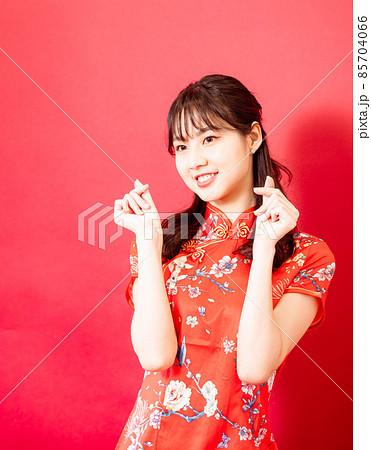 Beauty young woman wear cheongsam and hold mini heart in chinese new year on red background. 85704066