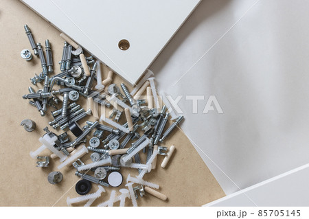Opened box with furniture assembly parts, closeup Opened box with furniture assembly parts, closeup 85705145