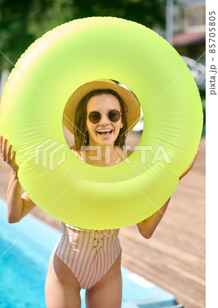 Pretty smiling woman with a tube feeling cheerful Pretty smiling woman with a tube feeling cheerful 85705805