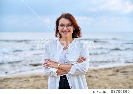 Outdoor portrait of successful middle aged woman with folded hands. 85706890