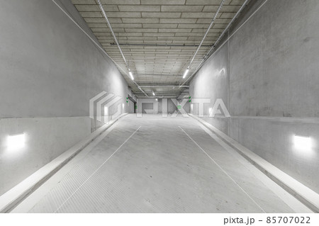Empty public underground parking lot or garage interior with concrete stripe painted columns and signs Empty public underground parking lot or garage interior with concrete stripe painted columns and signs 85707022