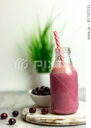 A bottle of cherry smoothies on a white background, cherries in bulk and in a plate. Morning summer breakfast A bottle of cherry smoothies on a white background, cherries in bulk and in a plate. Morning summer breakfast 85707231
