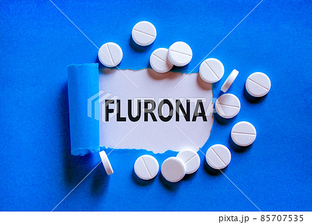 Covid-19 corona and flu flurona symbol. The concept word flurona appearing behind torn blue paper. White pills. Beautiful blue background. Medical, covid-19 corona and flu flurona concept. Copy space. 85707535