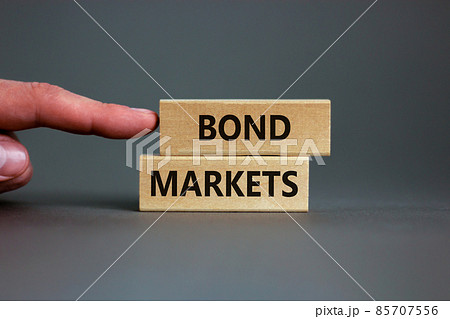 Bond markets symbol. Wooden blocks with words 'Bond markets' on beautiful grey background, copy space. Businessman hand. Business and bond markets concept. Bond markets symbol. Wooden blocks with words 'Bond markets' on beautiful grey background, copy space. Businessman hand. Business and bond markets concept. 85707556