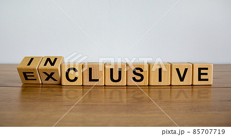 Symbol for a better inclusive. Inverted cube and changed word exclusive to inclusive. Beautiful wooden table, white background. Copy space. 85707719