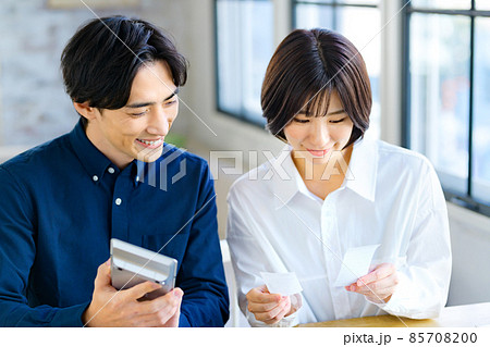 自宅でレシートを見ながら計算する若い夫婦の確定申告イメージ 自宅でレシートを見ながら計算する若い夫婦の確定申告イメージ 85708200