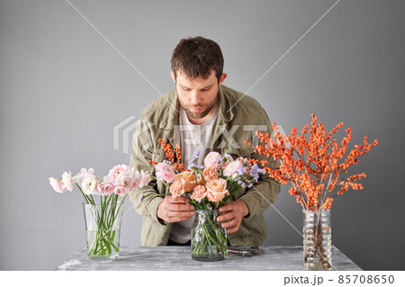 Portrait of a Male florist. Flowers bunch, set for home. Fresh cut flowers for decoration home. European floral shop. Delivery fresh cut flower. 85708650