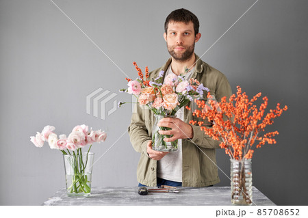 Portrait of a Male florist. Flowers bunch, set for home. Fresh cut flowers for decoration home. European floral shop. Delivery fresh cut flower. Portrait of a Male florist. Flowers bunch, set for home. Fresh cut flowers for decoration home. European floral shop. Delivery fresh cut flower. 85708652