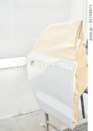 Painting the rear door of the car in special painting chamber. Car service station. Restoring a car after an accident 85708671