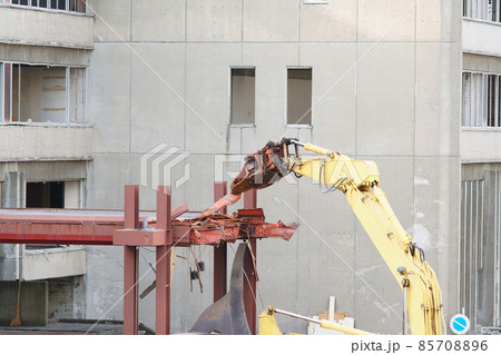 老朽化した公共建造物の解体作業をする重機 85708896