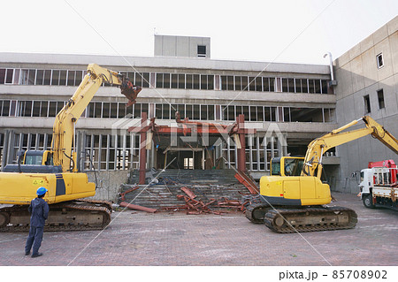老朽化した公共建造物の解体作業をする重機 85708902