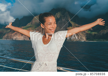 Fun cruise vacation happy woman happy with open arms on Kauai Na Pali Coast ship tour looking at mountain coast. Summer travel lifestyle 85708936