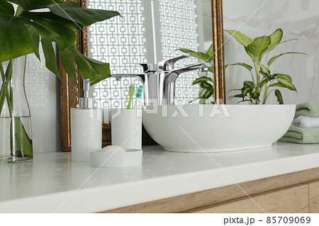 Toiletries and sink near vintage mirror in bathroom Toiletries and sink near vintage mirror in bathroom 85709069