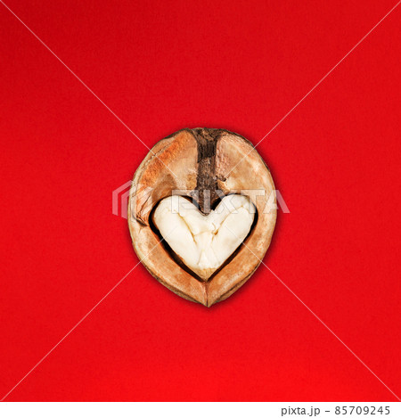 Funny Minimalistic Saint Valentine Day concept, open half of walnut with core looking like heart or owl 85709245