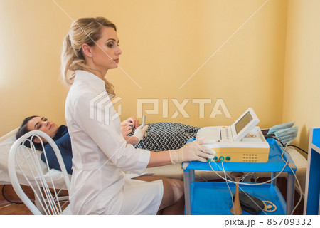 beautiful gynecologist examines the medical devices. The patient lies on the couch beautiful gynecologist examines the medical devices. The patient lies on the couch 85709332