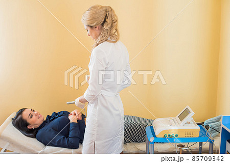 beautiful gynecologist examines the medical devices. The patient lies on the couch 85709342