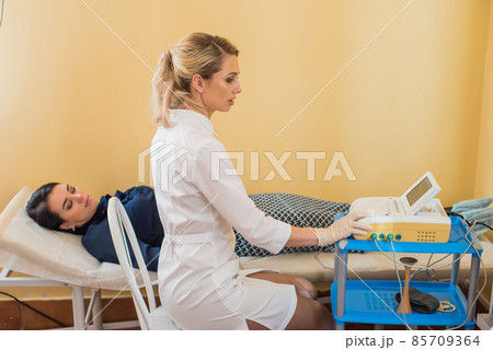 beautiful gynecologist examines the medical devices. The patient lies on the couch beautiful gynecologist examines the medical devices. The patient lies on the couch 85709364