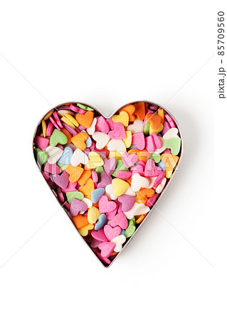 Multi-colored heart-shaped pastry topping in heart form on white background 85709560