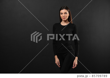 Woman wearing thermal underwear on black background. Space for text 85709789