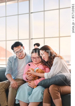 Happy asian family sitting on sofa and playing dolls with their daughter down syndrome child in living room at morning time, Activity happy family lifestyle concept, Happy asian family sitting on sofa and playing dolls with their daughter down syndrome child in living room at morning time, Activity happy family lifestyle concept, 85710961