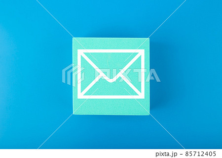 Email concept. Envelope drawn on toy square against blue background 85712405