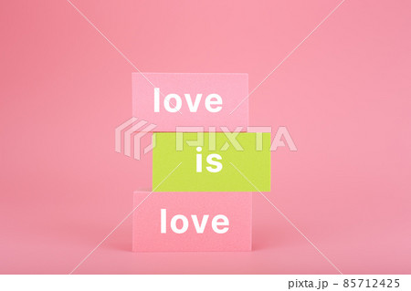 Love is love written on stack of yellow and pink rectangles on pink background. Lgbtq plus concept Love is love written on stack of yellow and pink rectangles on pink background. Lgbtq plus concept 85712425