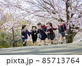 桜の咲く公園を走る新一年生 85713764