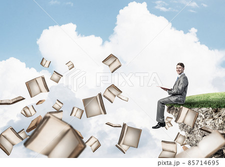 Man reading book and many of them flying in air Man reading book and many of them flying in air 85714695