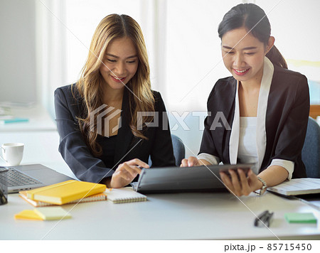 Business women looking at tablet screen and thinking a creative ideas together. 85715450