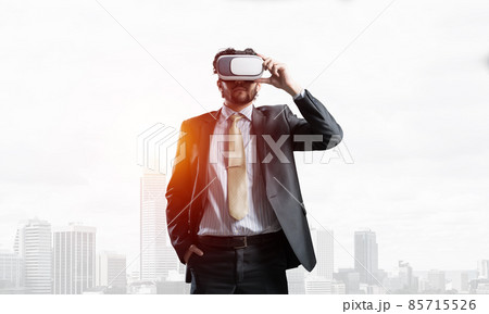 Handsome elegant businessman experiencing impressive virtual reality and business city at backdrop 85715526