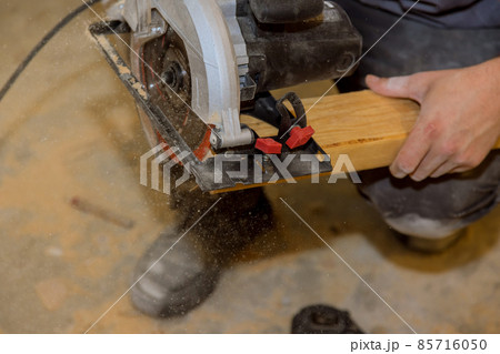 Close Up process cutting of hand circular saw at wood beam cuts Close Up process cutting of hand circular saw at wood beam cuts 85716050