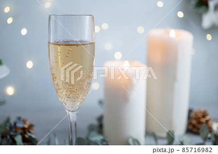 クリスマスディナーのドリンク｜キャンドルとイルミネーションが輝く背景 85716982