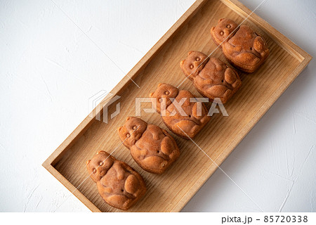 木のトレイに5つ並んだたぬきの人形焼き 85720338