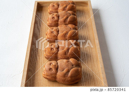 木のトレイに5つ並んだたぬきの人形焼き 85720341