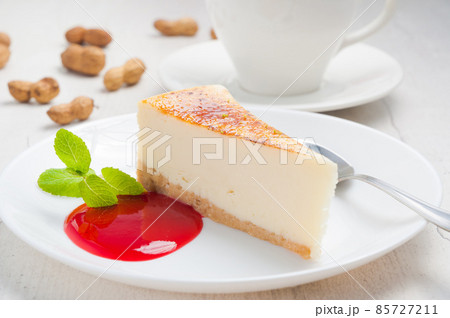 homemade cheesecake on a white plate with strawberry sauce 85727211