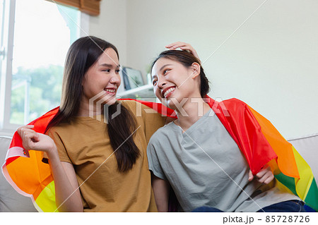 happy asian girl homosexual with gay flag. lesbian couple, symbolic expression LGBTQ flag. 85728726