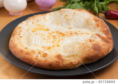 Khachapuri Megrelian Georgian cuisine on a dark plate 85728809