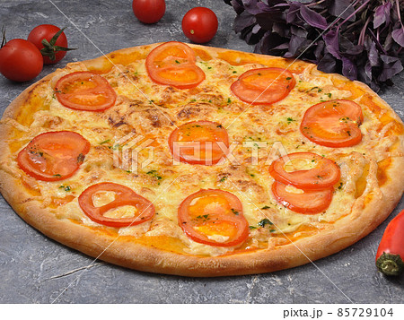 pizza Margarita on a gray background decorated with vegetables 85729104