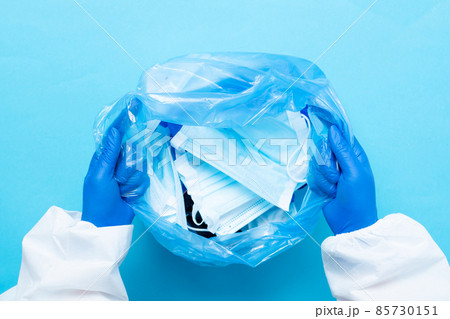 Used hygienic mask in the trash bin, infectious waste, prevented virus covid-19 by separating infected waste. Quarantine is over background. Facemask utilization. Usage of one-use face mask 85730151