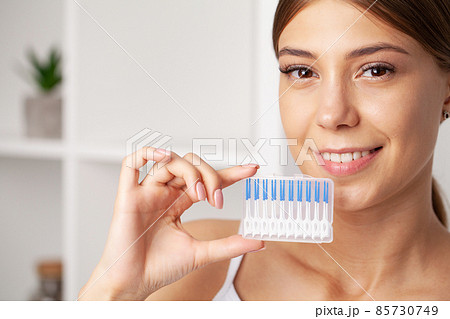 The woman uses brushes to clean the interdental spaces 85730749