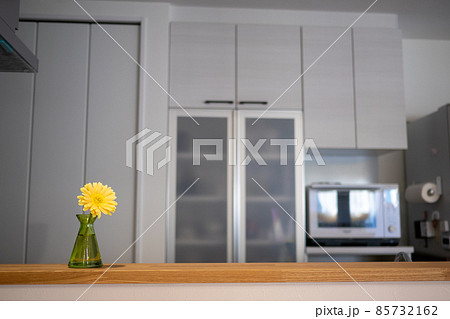 キッチンのカウンターに飾ってある黄色いガーベラの花の写真素材