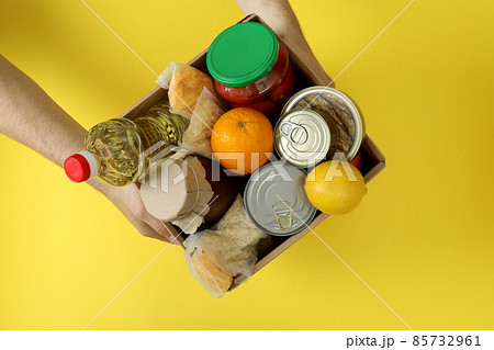 Male hands hold donation box on yellow background 85732961