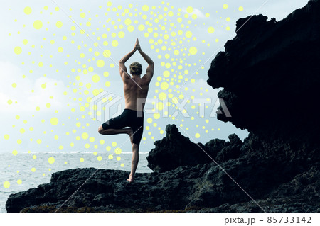 A photo of an athlete man practising yoga combined with yellow dots. 85733142