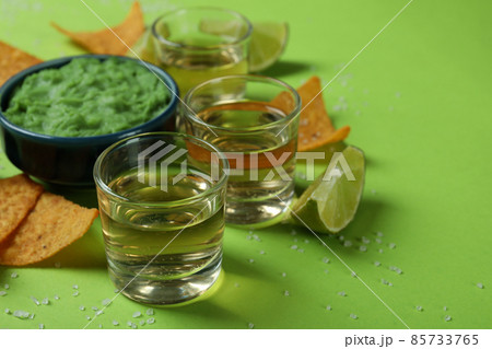Party concept with tequila, guacamole and chips Party concept with tequila, guacamole and chips 85733765