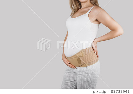 Pregnant woman belly in prenatal pregnancy maternity belt. Orthopedic abdominal support waist, back, abdomen band. Belly brace or band for pregnancy. Horizontal web banner. Torso of pregnant model. 85735941