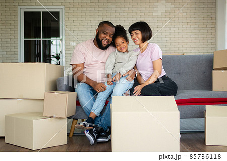 Mixed Race families are sitting on the sofa for rest after moving to a new house on the first day after buying real estate.  Concept of starting a new life for a new family. 85736118
